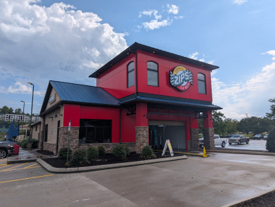 Outside of newly refreshed Moss Grove ZIPS Car Wash location with a bright, shining red exterior