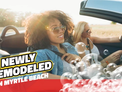 Two women smiling driving a clean car with bubbles. Text reads: "Newly Remodeled in Myrtle Beach"